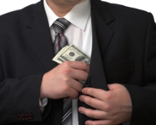 A man putting a bribe into his pocket.